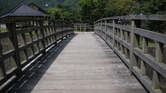 A wooden bridge and mountain scenics in the Japanese countryside