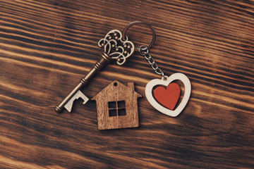 home sweet home concept . House key  with  heart shape keyring on old wood background