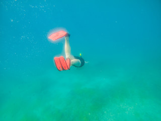 man swimming underwater with snorkeling musk