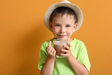 Little boy with tasty chocolate milk on color background