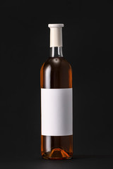 Bottle of wine with blank label on dark background. Mockup for design