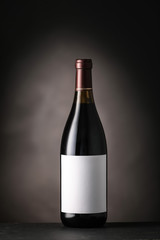 Bottle of wine with blank label on dark background. Mockup for design