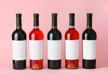 Bottles of wine with blank labels on color background. Mockup for design