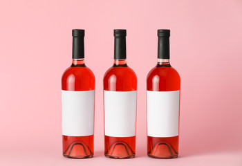 Bottles of wine with blank labels on color background. Mockup for design