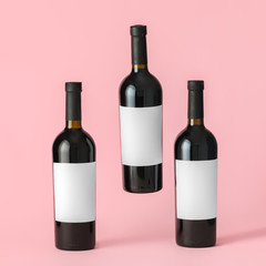 Bottles of wine with blank labels on color background. Mockup for design