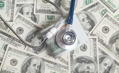 Stethoscope on dollar banknotes background.