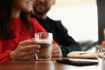 Lovely couple with fresh aromatic coffee at table in cafe, closeup