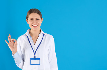 Portrait of young doctor on blue background, space for text