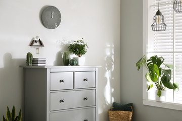 Grey chest of drawers in stylish room interior