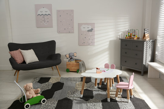Cute children's room interior with sofa and little table