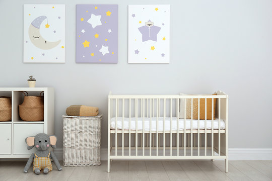 Baby room interior with crib and cute posters on wall