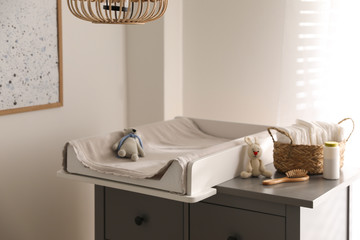 Chest of drawers with changing pad and tray in nursery. Baby room interior design © New Africa
