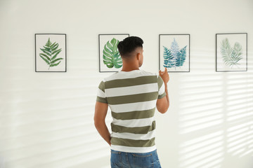 Man at exhibition in art gallery, back view