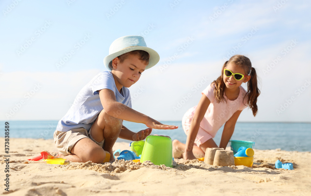 Sticker cute little children playing with plastic toys on sandy beach