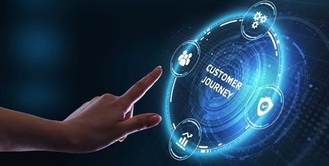 Business, technology, internet and networking concept. Young businessman working on his laptop in the office, select the icon Customer journey on the virtual display.