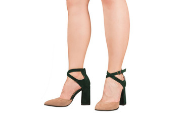 Woman legs in green and beige sandals on heels.
