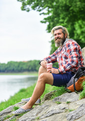 Naklejka na ściany i meble Man with cup outdoors. Man outdoors with cup of coffee. Drinking hot coffee. Enjoying nature at riverside. Guy with backpack relaxing. Inspiration. Inspired handsome hipster. Drink tea or coffee