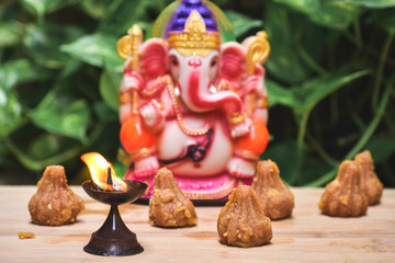Close up shot of Diya in front of statue of lord Ganesha during the Ganesh Chaturthi festival.