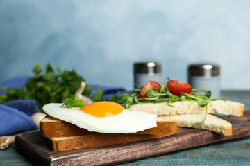 Tasty fried egg with bread on wooden board