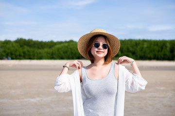 Happy traveller asian woman wearing hat and glasses at the beach,Enjoying and relaxing time