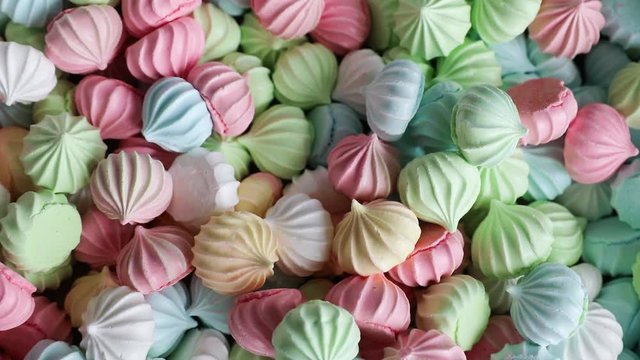 a plate full of colorful meringue cookies on a white background
