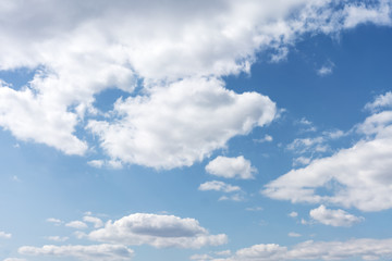 .White cumulus clouds against the background against blue on a blue background.