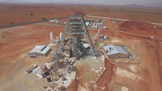 Aerial shot. Mineshaft winding tower construction in dry African bush.