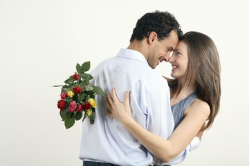 Woman hugging man for giving her a bouquet of flowers