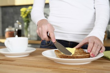 Woman spreading butter on toast
