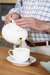 Senior man pouring tea into cup