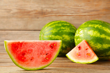 Fresh ripe striped sliced watermelon on grey background.