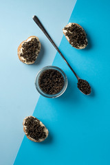 Sandwiches with black caviar on a blue background.