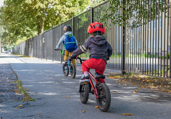 Two children ride down the street on bicycles. Bmx ride.