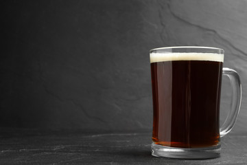 Mug of delicious kvass in mug on black table. Space for text