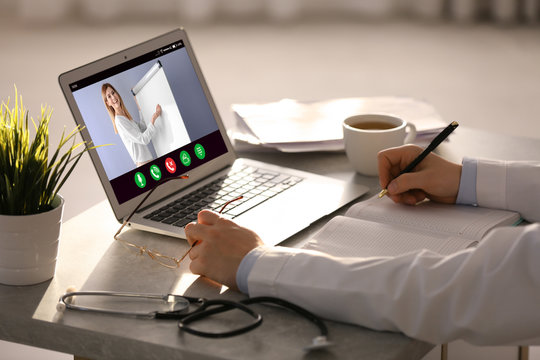Doctor having online video consultation with business trainer at table, closeup