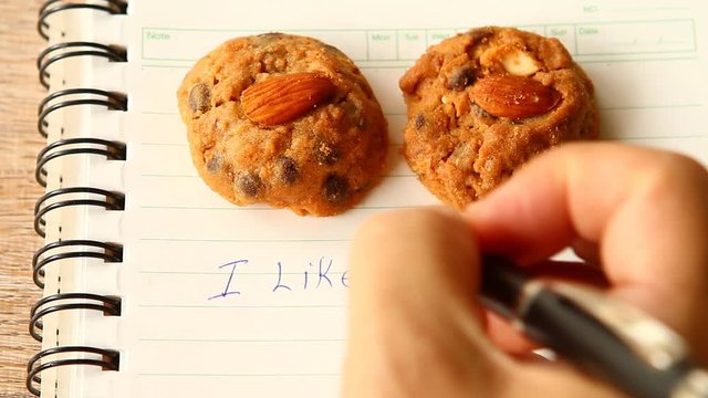Writing  &ldquo;I like cookies&rdquo; word on the book , with cookies  background