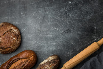Rustic bread of whole wheat grains on dark background with copy space.