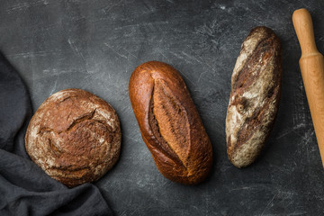 Rustic bread on dark background. Flat lay.