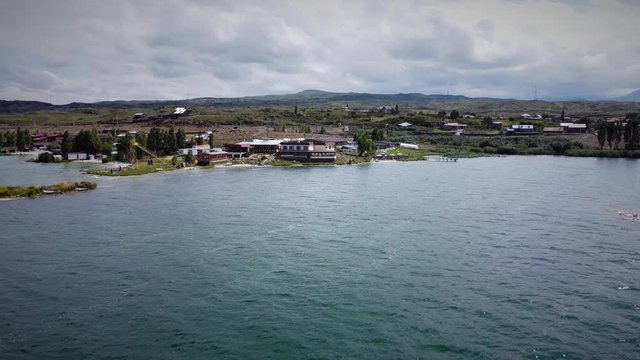 Drone Flying forward (zooming in) to the Coastline with the Hotel Building and beautiful mountains at the background
