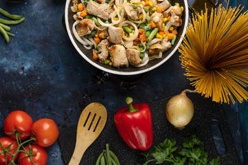 Cooking meat with vegetables on a wok, on the background of vegetables and a hot wok.Flat lay