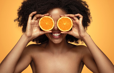 Happy black lady playing with orange