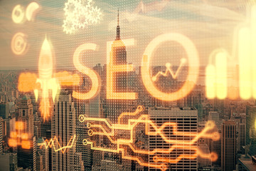 SEO hologram on city view with skyscrapers background double exposure. Search optimization concept.