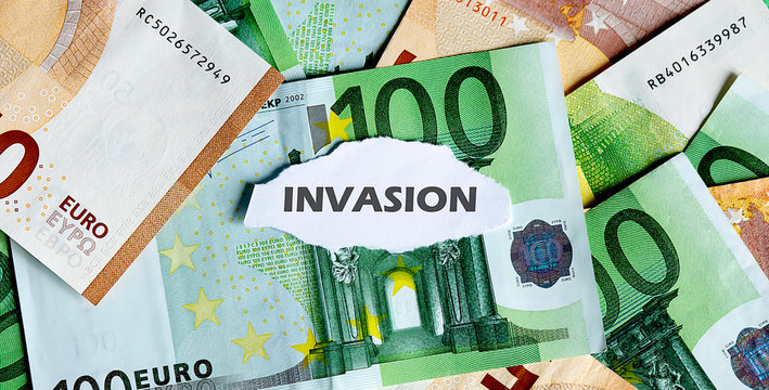 Focus on the word INVASION , on piece of torn white paper with EUROS currency as a background.