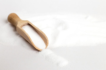 Salt grain in wooden spoon top view on a white background , flat lay.