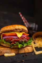 Homemade burger with french fries and soda on a black background, homemade recipes