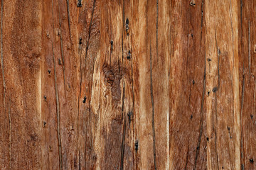 The texture of a very old cracked brown wood.