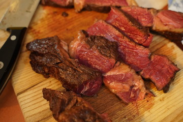 Sliced medium rare grilled Beef steak Ribeye on cutting board on wooden background