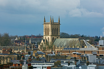 Skyline of the city centre of Cambridge with spire of St John's Church under rainy skies