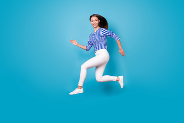 Fototapeta na wymiar Full length body size profile side view of her she nice attractive pretty motivated energetic cheerful cheery girl jumping running having fun isolated bright vivid shine vibrant blue color background