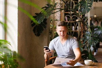 European confident businessman working with documents at cafe.